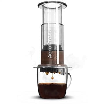 AeroPress coffee maker brewing into a glass mug